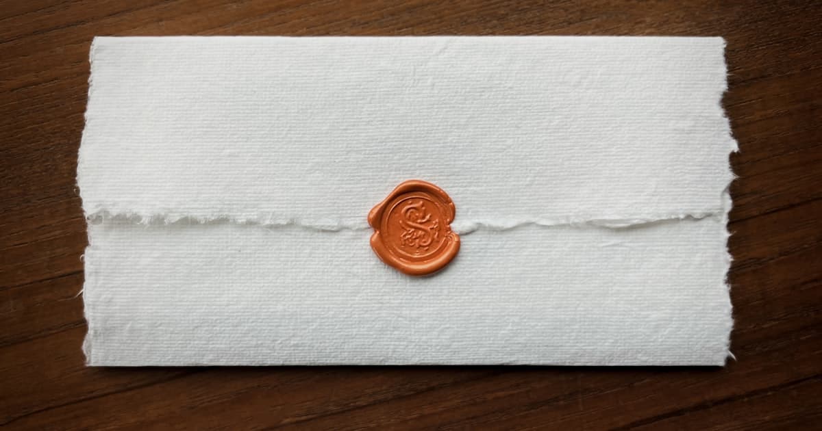 Sceau de cire rouge sur un document en papier artisanal, illustrant le caractere officiel et definitif de l'acte de vente authentique