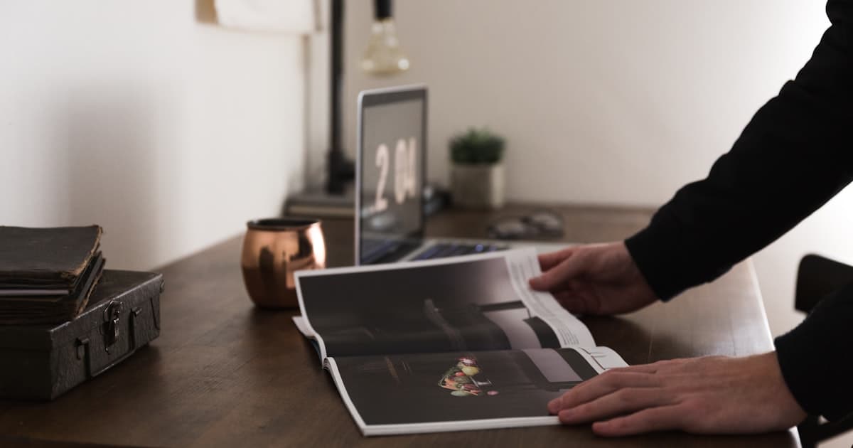 Personne feuilletant un catalogue de formations sur un bureau, comparant plusieurs organismes