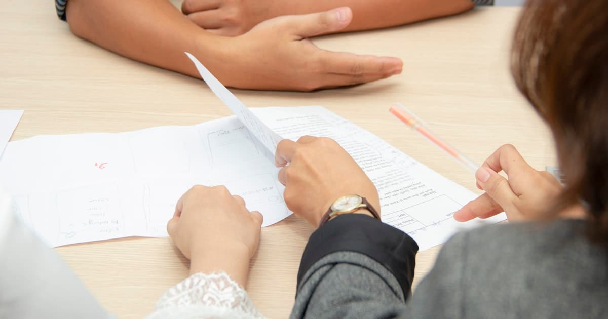 Deux professionnels examinant ensemble un dossier de formation continue sur une table de bureau